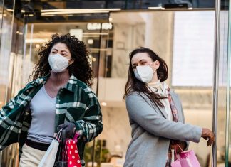 Best Shopping in Newark: A Local Guide to the Top Spots in 2026 Low angle of woman with purchases in colorful shopping bags walking through doors of store during coronavirus pandemic