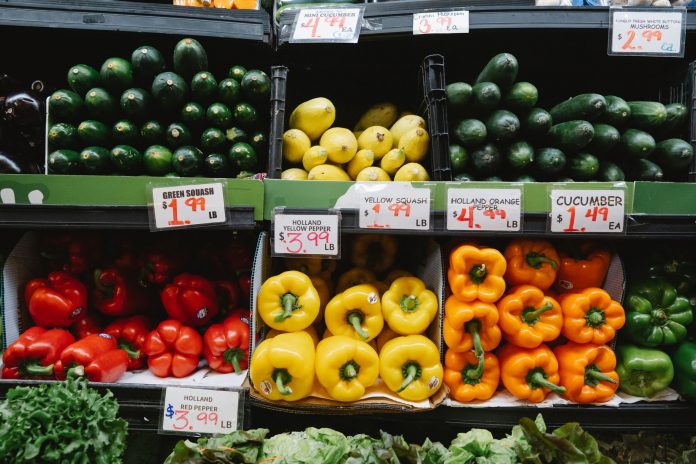 best-supermarkets-in-west-new-york Colorful assortment of fresh vegetables at a supermarket display, highlighting peppers, squash, and cucumbers.