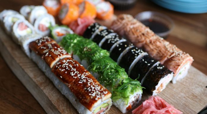 A delicious selection of sushi rolls with toppings like seaweed and sesame seeds on a wooden platter.