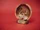 A close-up of a golden music award trophy against a vibrant red background.