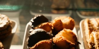 BREAKING: Baking Mama Opening New Jersey City Location Warm-toned close-up of assorted pastries in a bakery display, sunlight highlighting texture.