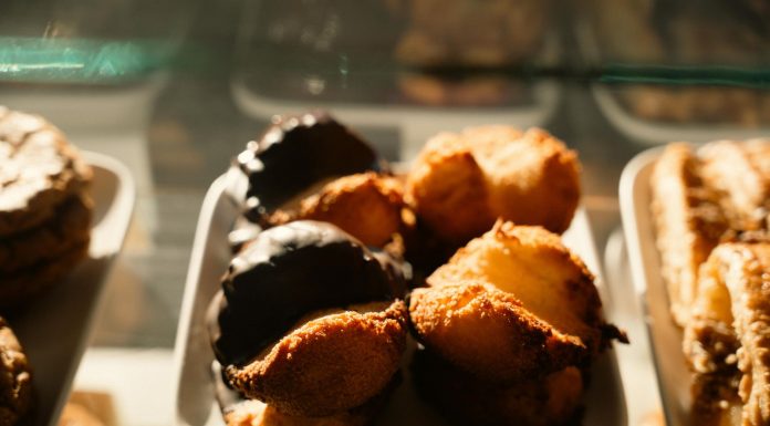 BREAKING: Baking Mama Opening New Jersey City Location Warm-toned close-up of assorted pastries in a bakery display, sunlight highlighting texture.