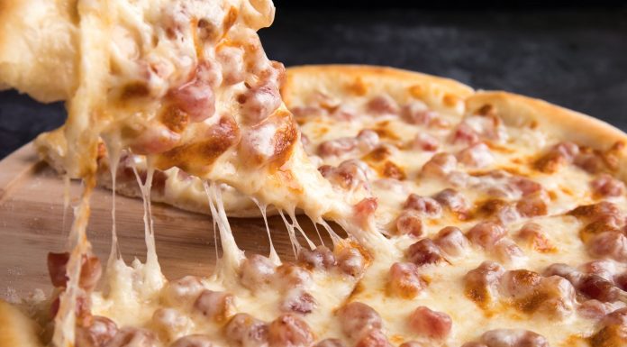 Close-up of a delicious pepperoni pizza slice with gooey mozzarella cheese.