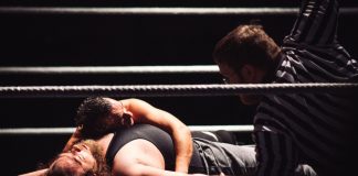 Intense wrestling match showcasing a dramatic pinfall with referee counting.
