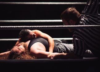 Intense wrestling match showcasing a dramatic pinfall with referee counting.