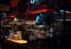 BREAKING: Café at Journal Squared Launches After-Hours Menu Warm lit bar scene in Katowice, showcasing Aperol decor and cozy atmosphere at night.
