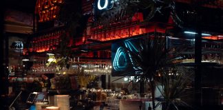 BREAKING: Café at Journal Squared Launches After-Hours Menu Warm lit bar scene in Katowice, showcasing Aperol decor and cozy atmosphere at night.