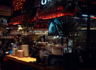 Warm lit bar scene in Katowice, showcasing Aperol decor and cozy atmosphere at night.