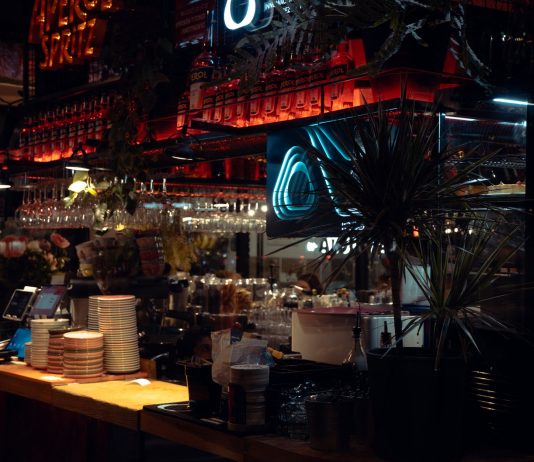 BREAKING: Café at Journal Squared Launches After-Hours Menu Warm lit bar scene in Katowice, showcasing Aperol decor and cozy atmosphere at night.