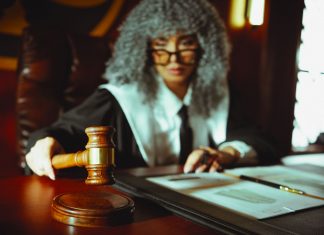 A judge in a courtroom holding a gavel, focused on legal documents.