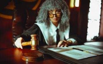 A judge in a courtroom holding a gavel, focused on legal documents.