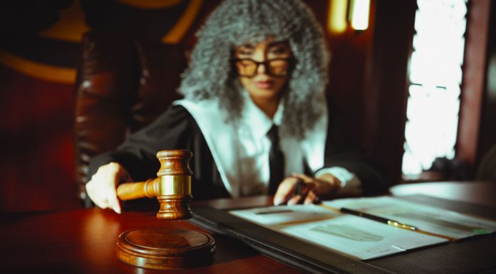 A judge in a courtroom holding a gavel, focused on legal documents.