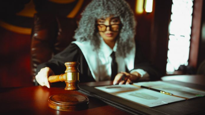 breaking-guilty-verdict-in-2024-hoboken-murder-of- A judge in a courtroom holding a gavel, focused on legal documents.