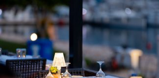 BREAKING: Halifax in Hoboken Celebrates 10 Years of Farm-to-Fork Dining Charming outdoor restaurant setup with lamps and wine glasses by a marina at twilight.