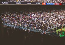A vibrant crowd fills a football stadium during a lively match.