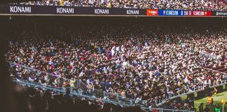 A vibrant crowd fills a football stadium during a lively match.