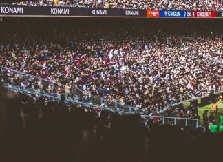 A vibrant crowd fills a football stadium during a lively match.