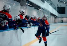 Ice hockey team players celebrating during a game in an indoor rink.