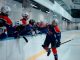 Ice hockey team players celebrating during a game in an indoor rink.