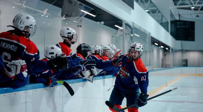 Ice hockey team players celebrating during a game in an indoor rink.