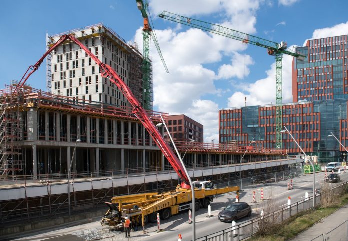 breaking-jersey-city-approves-controversial-libert Busy construction site in Hamburg with cranes and trucks under a clear sky.