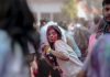 BREAKING: Jersey City Hosts Color Festival, Night Market This Weekend Vibrant Holi festival scene with people celebrating with colorful powders outdoors.