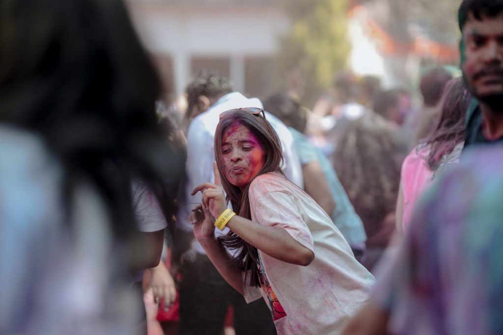 Vibrant Holi festival scene with people celebrating with colorful powders outdoors.