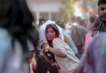 Vibrant Holi festival scene with people celebrating with colorful powders outdoors.