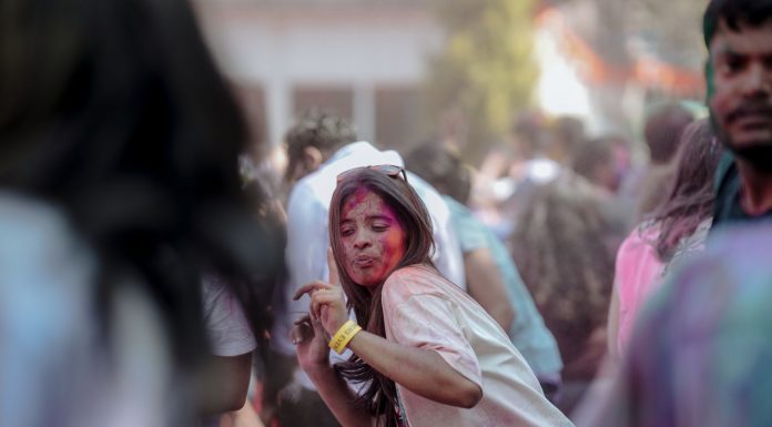 Vibrant Holi festival scene with people celebrating with colorful powders outdoors.