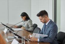Business professionals in a conference setting, focusing on documents and reports.