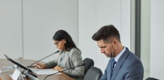 Business professionals in a conference setting, focusing on documents and reports.