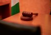 A close-up of a gavel on a courtroom desk representing law and justice.