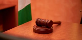 A close-up of a gavel on a courtroom desk representing law and justice.