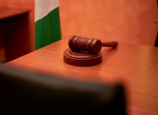 A close-up of a gavel on a courtroom desk representing law and justice.