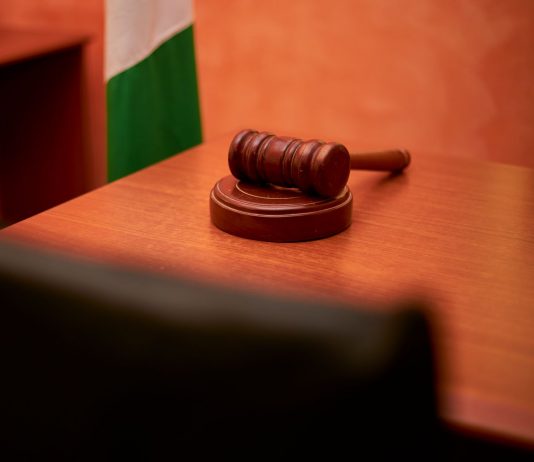 A close-up of a gavel on a courtroom desk representing law and justice.