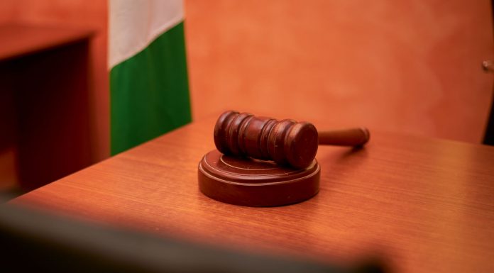 A close-up of a gavel on a courtroom desk representing law and justice.