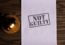 A courtroom document labeled 'Not Guilty' beside a gavel symbolizes justice.
