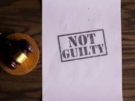 A courtroom document labeled 'Not Guilty' beside a gavel symbolizes justice.