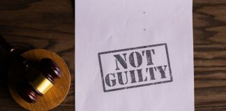 A courtroom document labeled 'Not Guilty' beside a gavel symbolizes justice.
