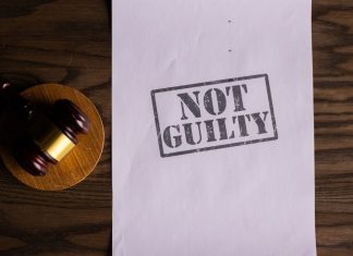 A courtroom document labeled 'Not Guilty' beside a gavel symbolizes justice.