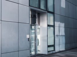 BREAKING: New Jersey Opens Free Jersey City Office Space for Foreign Companies Sleek modern architecture featuring a glass entrance with reflective facade, showcasing contemporary design.