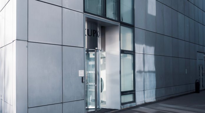BREAKING: New Jersey Opens Free Jersey City Office Space for Foreign Companies Sleek modern architecture featuring a glass entrance with reflective facade, showcasing contemporary design.