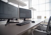 Stylish contemporary office featuring multiple computer monitors and ergonomic chairs.