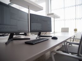 Stylish contemporary office featuring multiple computer monitors and ergonomic chairs.