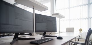 Stylish contemporary office featuring multiple computer monitors and ergonomic chairs.
