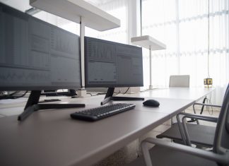 Stylish contemporary office featuring multiple computer monitors and ergonomic chairs.