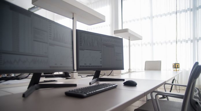 Stylish contemporary office featuring multiple computer monitors and ergonomic chairs.