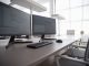 Stylish contemporary office featuring multiple computer monitors and ergonomic chairs.