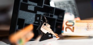 Keys with a house model, Euro bills, and charts suggesting real estate and financial themes.