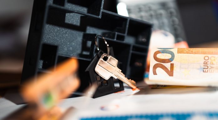 Keys with a house model, Euro bills, and charts suggesting real estate and financial themes.